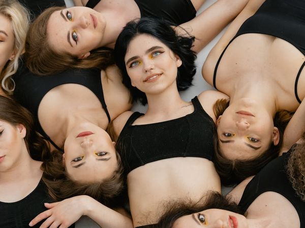 Diverse group of people smiling in a bright yoga studio.